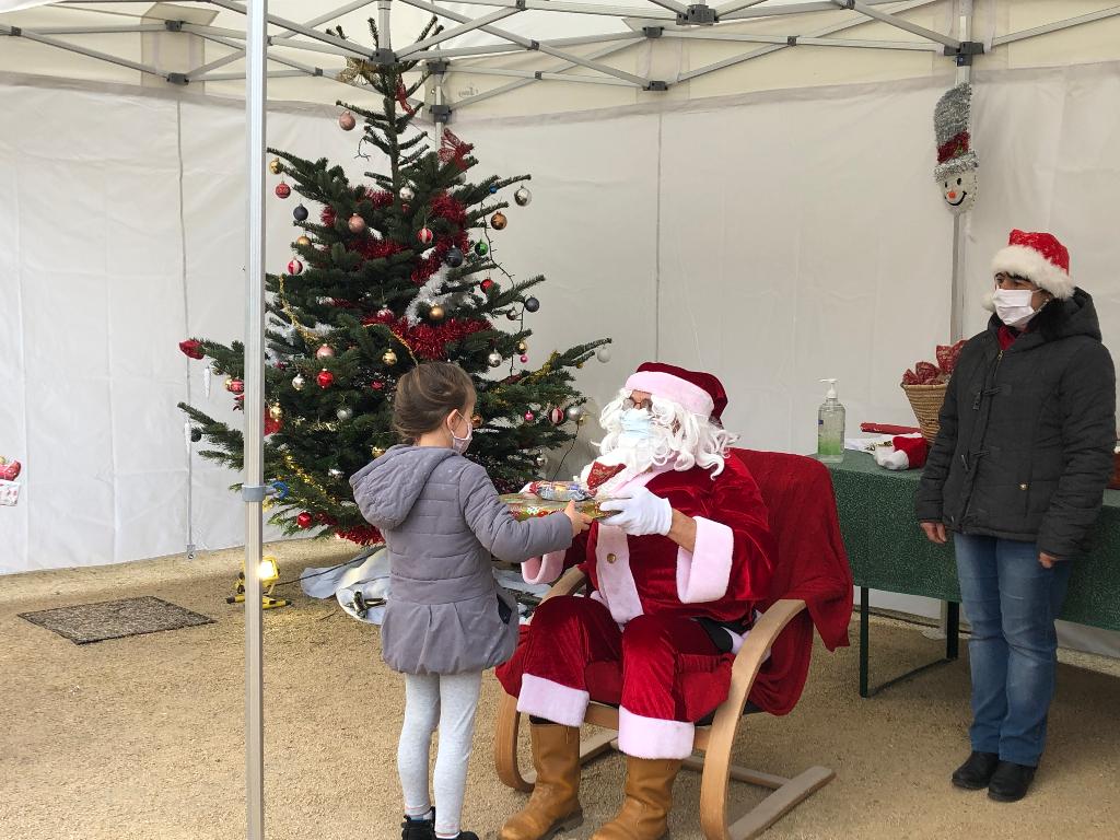 Le père Noël offre un cadeau à un enfant.